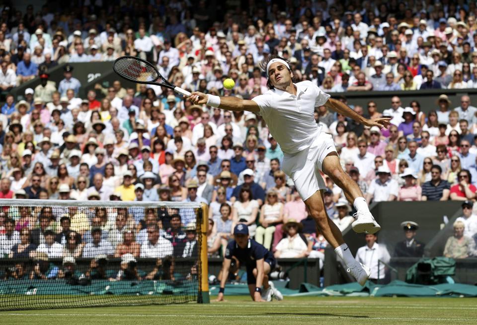 Roger Federer of Switzerland reaches to hit a return during his men's singles final tennis match against Novak Djokovic of Serbia at the Wimbledon Tennis Championships, in London July 6, 2014. REUTERS/SangTan