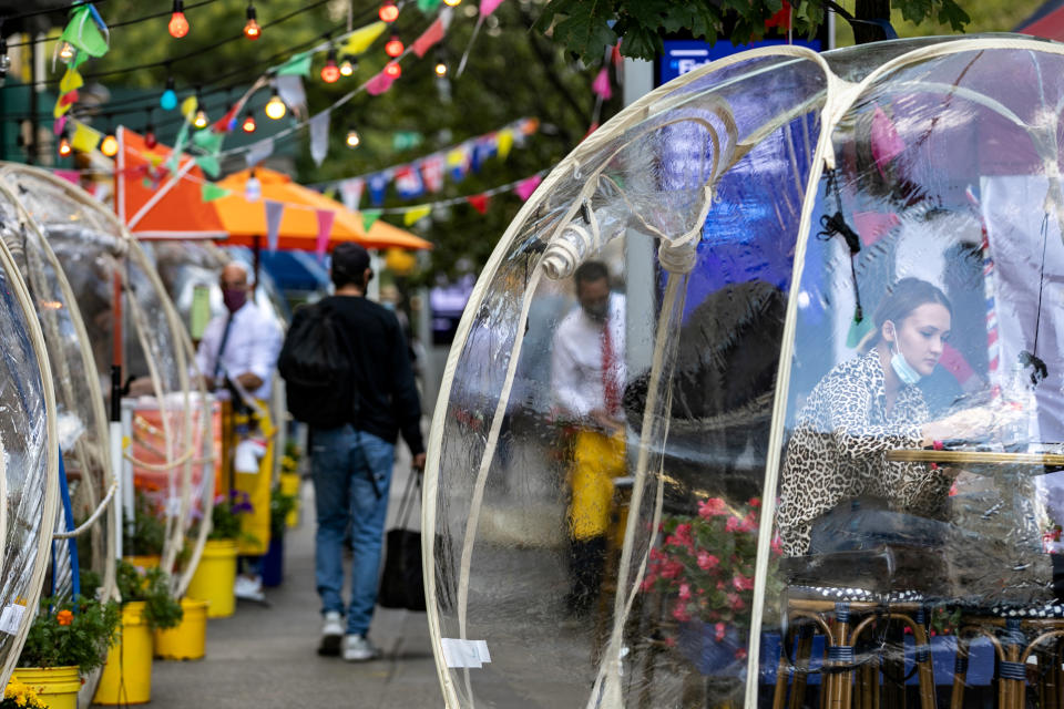 A woman sits outside Cafe Du Soleil under bubble tents following the outbreak of the coronavirus disease (COVID-19) in the Manhattan borough of New York City, New York, U.S., September 23, 2020.  REUTERS/Jeenah Moon     TPX IMAGES OF THE DAY