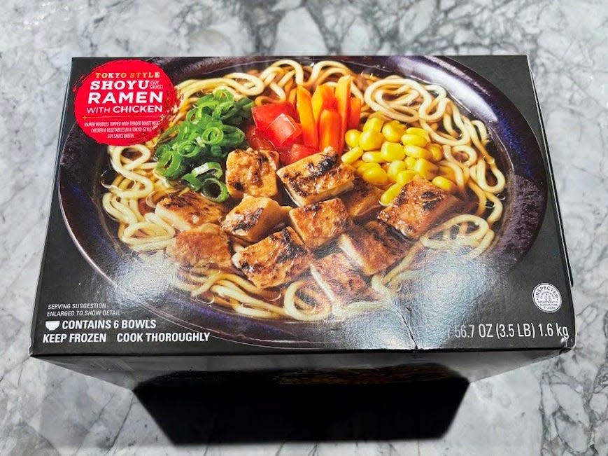 A black box of ramen with an image of a bowl of noodles, chicken, green onion, peppers, carrots, and corn on box