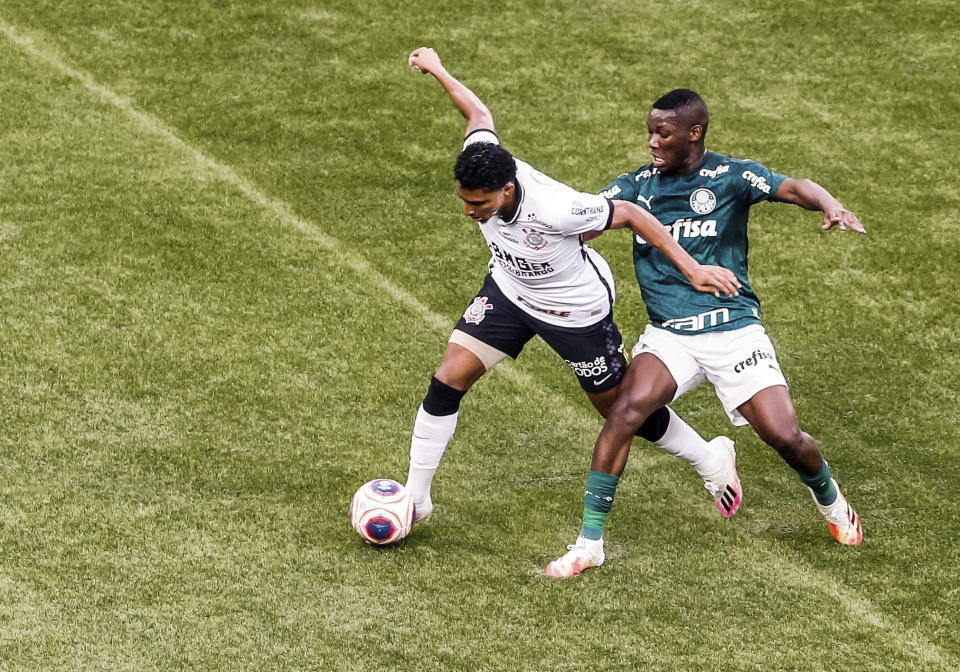 Corinthians' Ederson, left, fights for the ball with Palmeiras' Patrick de Paula during the Sao Paulo league final soccer match at Allianz Parque, Sao Paulo, Brazil, Saturday, Aug. 8, 2020. The match is being played without spectators to curb the spread of COVID-19. (AP Photo/Carla Carniel)