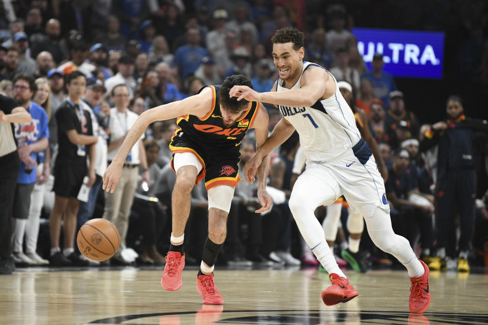 Oklahoma City Thunder forward Chet Holmgren, center left, tries to get to the ball before Dallas Mavericks center Dwight Powell, right, in the first half of an NBA basketball game, Sunday, April 14, 2024, in Oklahoma City. (AP Photo/Kyle Phillips)