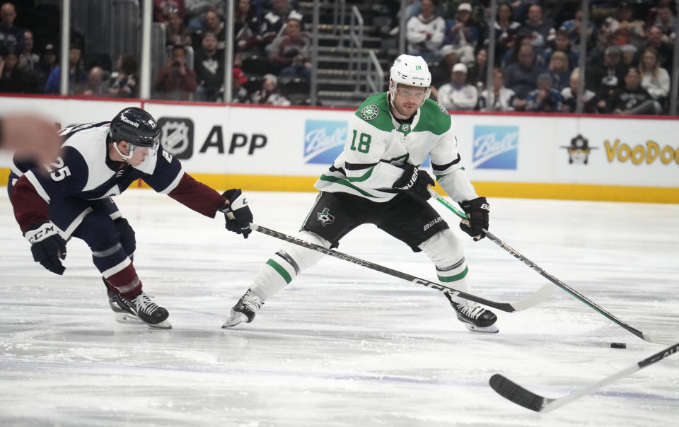 Dallas Stars center Max Domi, right, looks to pass the puck as Colorado Avalanche right wing Logan O'Connor defends in the second period of an NHL hockey game Saturday, April 1, 2023, in Denver. (AP Photo/David Zalubowski)