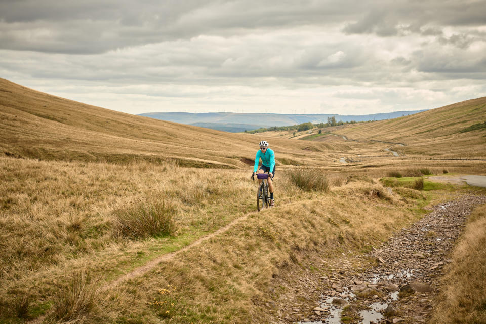 Male cyclist riding on gravel