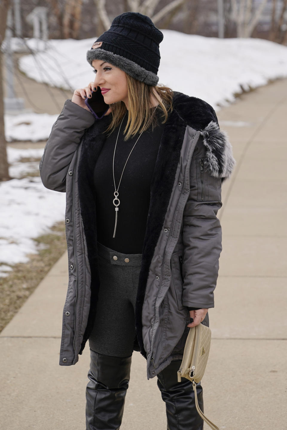 In this Monday, Feb. 8, 2021, photo, Allissa Star talks on her phone as she walks near the north shore of the Allegheny River in Pittsburgh. Starr worked about a week every month at a brothel in Pahrump, Nev., outside of Las Vegas. Then the pandemic led to the shuttering of Nevada's licensed bordellos, the only place where prostitution is legal in the state, and they have remained closed since March, leaving sex workers like Starr struggling to pay the bills and turning to alternatives like "virtual" dates. (AP Photo/Keith Srakocic)