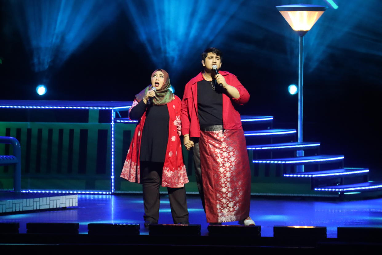 Local singer-songwriter Shazuan Shiraj, known as Abangsapau (right), performing his original song Each Other, with his mother Farhana binte Ibrahim, during a rehearsal for the National Day Parade 2020 Evening Show at the Star Performing Arts Centre. (Photo: NDP2020 Exco)