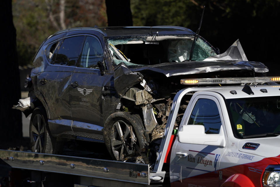 A vehicle is towed away from the site of a crash involving golfer Tiger Woods, Tuesday, Feb. 23, 2021, in the Rancho Palos Verdes suburb of Los Angeles. (AP Photo/Ashley Landis)