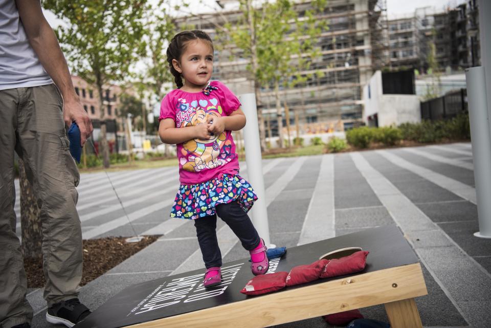 Olivia plays a game of cornhole with Craig Callaghan.