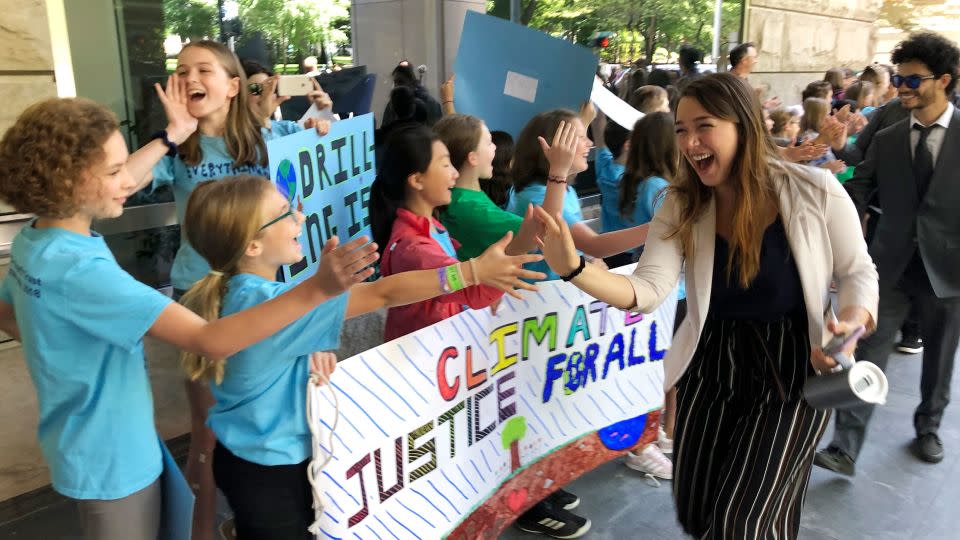 Kelsey Juliana of Eugene, Oregon, one of Juliana's lead plaintiffs, greets supporters outside a federal courthouse in Portland in 2019. - Andrew Selsky/AP