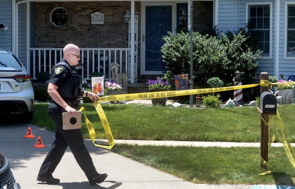 Springfield police officer Tamara Russell puts up crime scene tape in front of a home in the 1800 block of South Post Oak on June 13, 2024. Police are calling this a murder-suicide case.