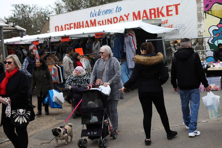 A woman with dogs walks through Dagenham Sunday Market in Dagenham, east London, Britain, March 31 2019. REUTERS/Hannah McKay