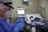 A nurse prepares a syringe for a patient infected with the coronavirus in the intensive care unit at the Syrian American Medical Society Hospital, in the city of Idlib, northwest Syria, Monday, Sept. 20, 2021. Coronavirus cases are surging to the worst levels of the pandemic in Idlib province, a rebel stronghold in Syria — a particularly devastating development in a region where scores of hospitals have been bombed and that doctors and nurses have fled in droves during a decade of war. (AP Photo/Ghaith Alsayed)