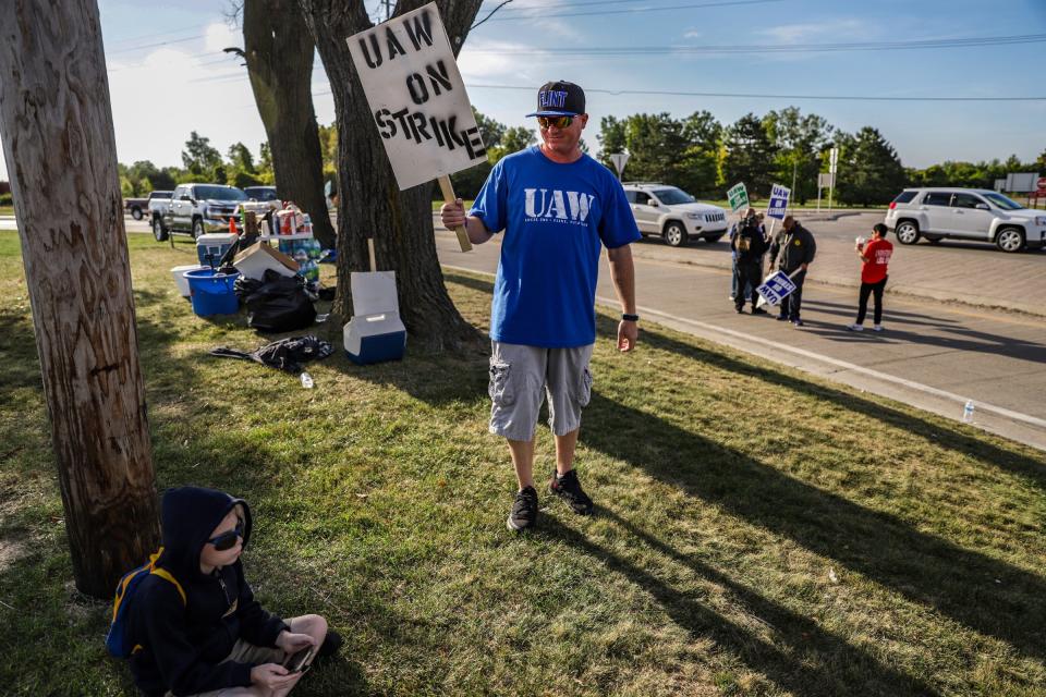 Erik Bond, 41, of Grand Blanc walks up to his son, Maximus, while striking together as a family outside of the General Motors Flint assembly plant on the fourth day of the nationwide strike.