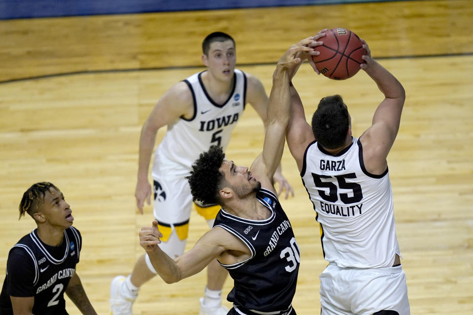 Grand Canyon's Gabe McGlothan (30) gets a hand on the shot of Iowa's Luka Garza (55) as Chance McMillian (2) and CJ Fredrick watch during the first half of a first round NCAA college basketball tournament game Saturday, March 20, 2021, at the Indiana Farmers Coliseum in Indianapolis. (AP Photo/Charles Rex Arbogast)