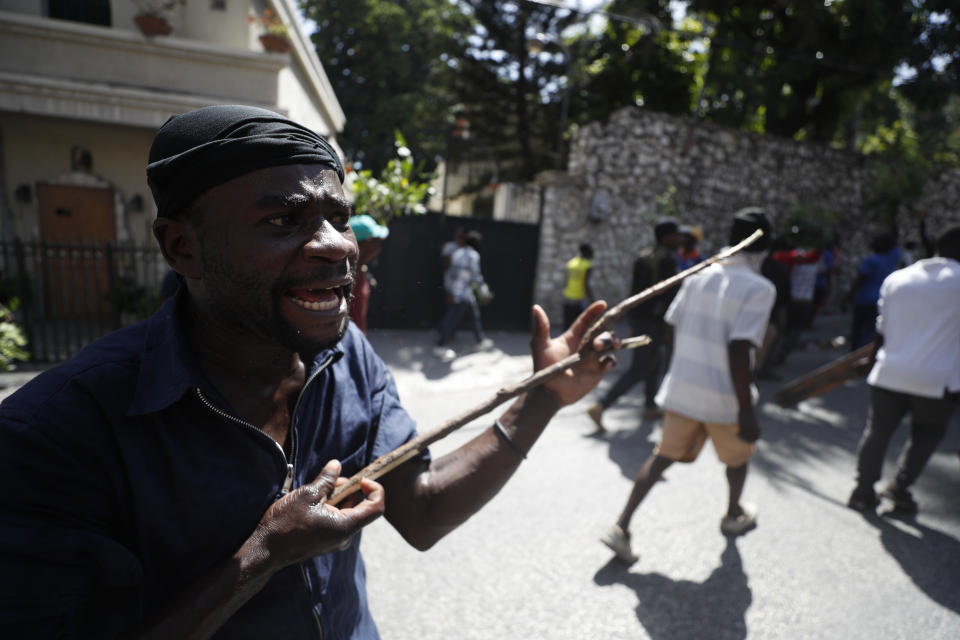 A man participates in an anti-government protest in Port-au-Prince, Haiti, Friday, Oct. 11, 2019. Protesters burned tires and spilled oil on streets in parts of Haiti's capital as they renewed their call for the resignation of President Jovenel Moïse just hours after a journalist was shot to death. (AP Photo/Rebecca Blackwell)