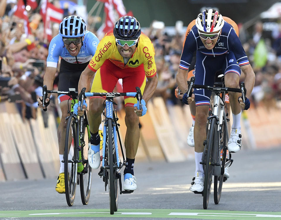 Spain's Alejandro Valverde, center, approaches the finish line to win the men's road race at the Road Cycling World Championships in Innsbruck, Austria, Sunday, Sept.30, 2018. (AP Photo/Kerstin Joensson)