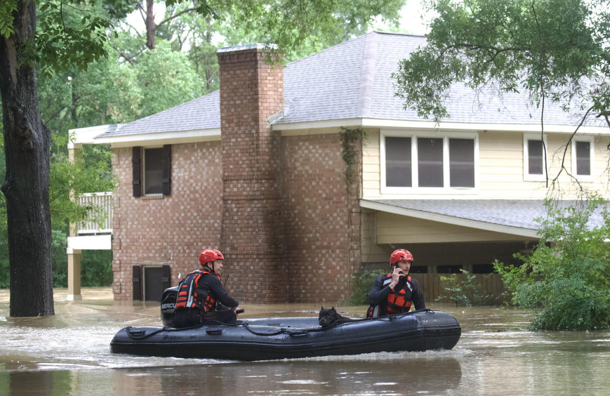 Emergency workers with Caney Creek Fire and Rescue boat out dogs from a flood portion of River Plantation Drive in River Plantation, Texas (Jason Fochtman / Houston Chronicle via Getty Images)