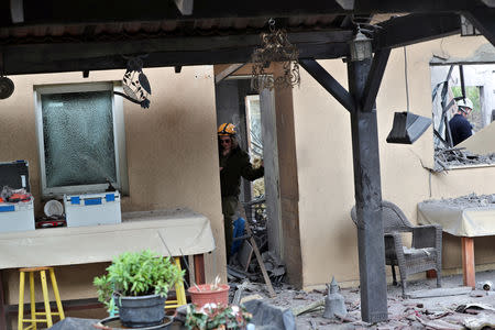 An Israeli soldier inspects a damaged house that was hit by a rocket north of Tel Aviv Israel March 25, 2019. REUTERS/ Ammar Awad