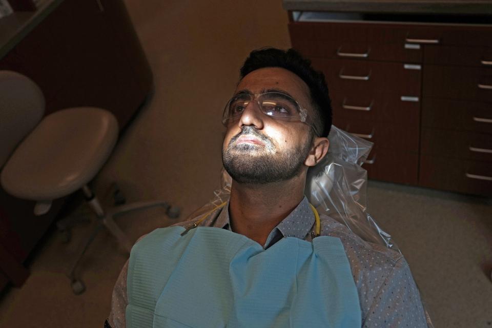 Abdul Wasi Safi waits in the dentist's chair during a clinic visit, Wednesday, April 26, 2023, in Houston. Safi's days since his release from a Texas immigration detention center have been filled with medical appointments while living in Houston with his brother. (AP Photo/David J. Phillip)