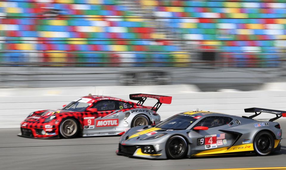 The No. 4 Corvette C8.R flies past the No. 9 Porsche 911 in the trioval, Friday January 21, 2022 during Weather Tech Championship practice at Daytona International Speedway.