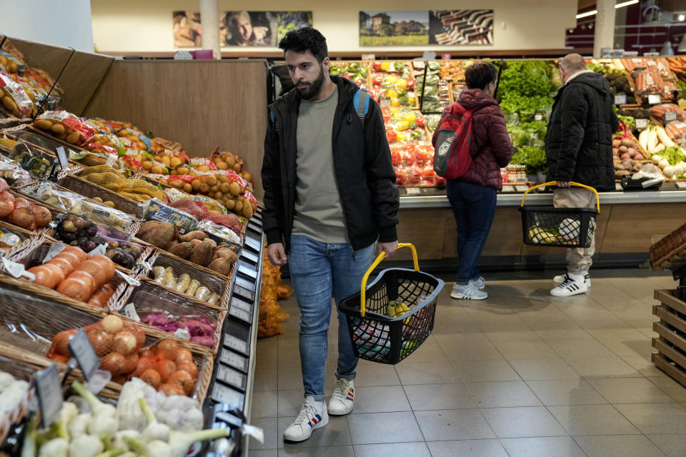 Jihad Ammuri, a 20-year-old Palestinian asylum seeker, is shopping in a grocery store in Eichsfeld, Germany, Wednesday, April 24, 2024. Across Germany, cities and counties are introducing new payment cards for asylum-seekers. The new rule, which was passed by parliament last month, calls for the migrants to receive their benefits on a card that can be used for payments in local shops and services. (AP Photo/Ebrahim Noroozi)
