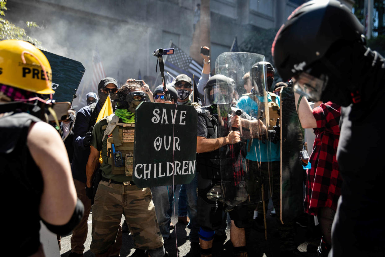 People, including one person holding a "Save Our Children" sign that refers to a QAnon conspiracy theory, participate in a protest against racial injustice in Portland, Oregon, U.S., August 22, 2020. (Maranie Staab/Reuters)