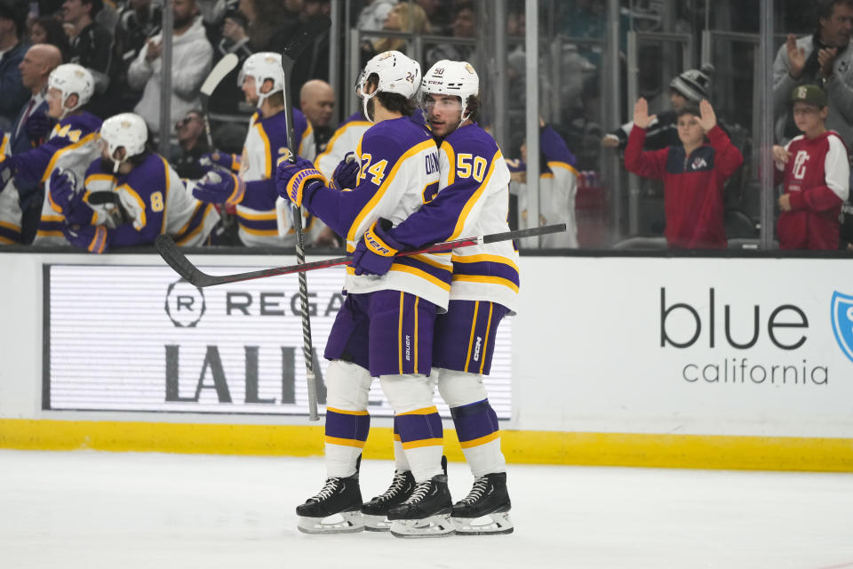 Los Angeles Kings' Phillip Danault (24) is hugged by Sean Durzi (50) after Danault scored against the San Jose Sharks during the first period of an NHL hockey game Saturday, Dec. 17, 2022, in Los Angeles. (AP Photo/Jae C. Hong)