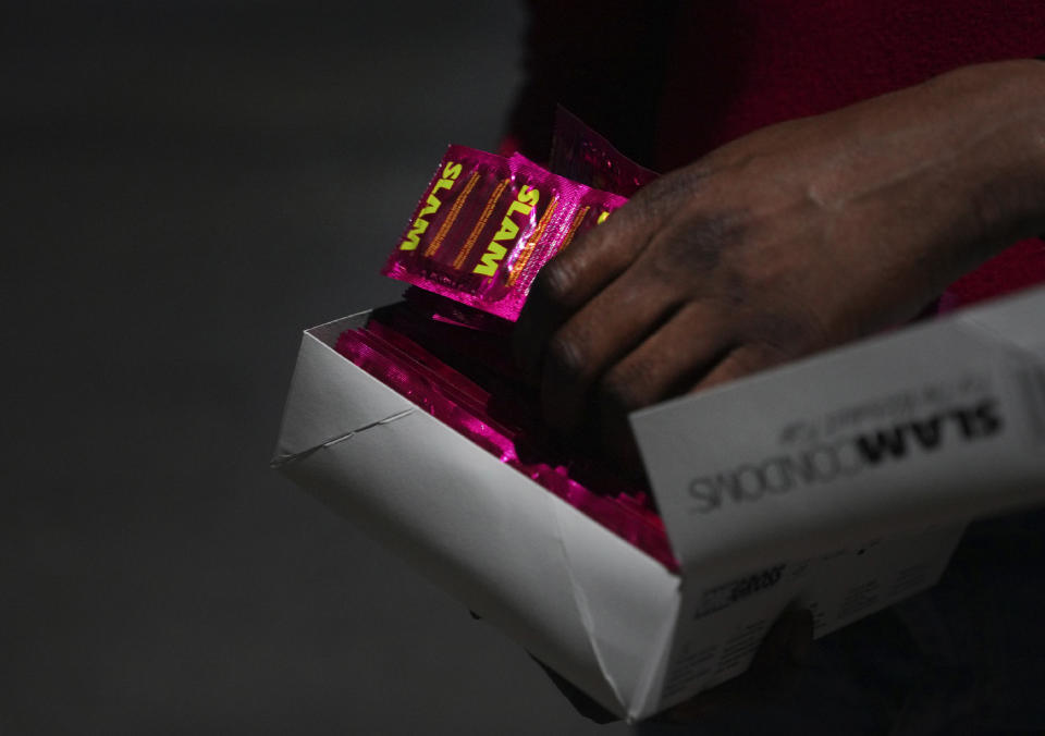 Orden David voluntarily distributes condoms to local sex workers, in St. John's, Antigua, early Saturday, May 13, 2023. (AP Photo/Jessie Wardarski)