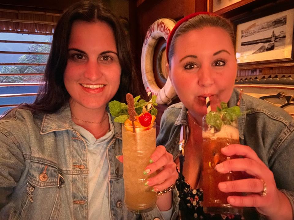 carly and her friend drinking cocktails at trader sams inside disneyland hotel