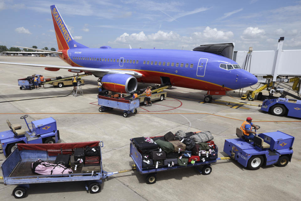 FILE - In this June 19, 2014 file photo, baggage carts are towed to the Boeing 737 jet at Bill and Hillary Clinton National Airport in Little Rock, Ark., June 19, 2014. Devices powered by lithium-ion batteries are overheating more often during airline flights and passengers often put them in checked bags that go into the cargo hold, where a fire might not be detected as quickly. (AP Photo/Danny Johnston, File)