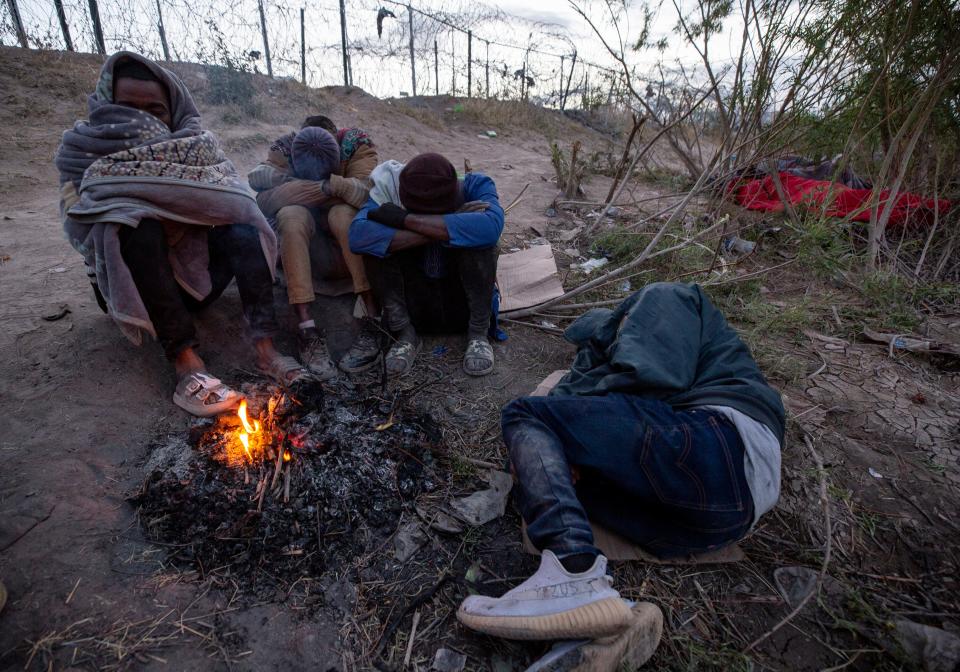 African migrants sleep next to a fire to keep warm in the early hours of Thursday morning along the Rio Grande in El Paso.