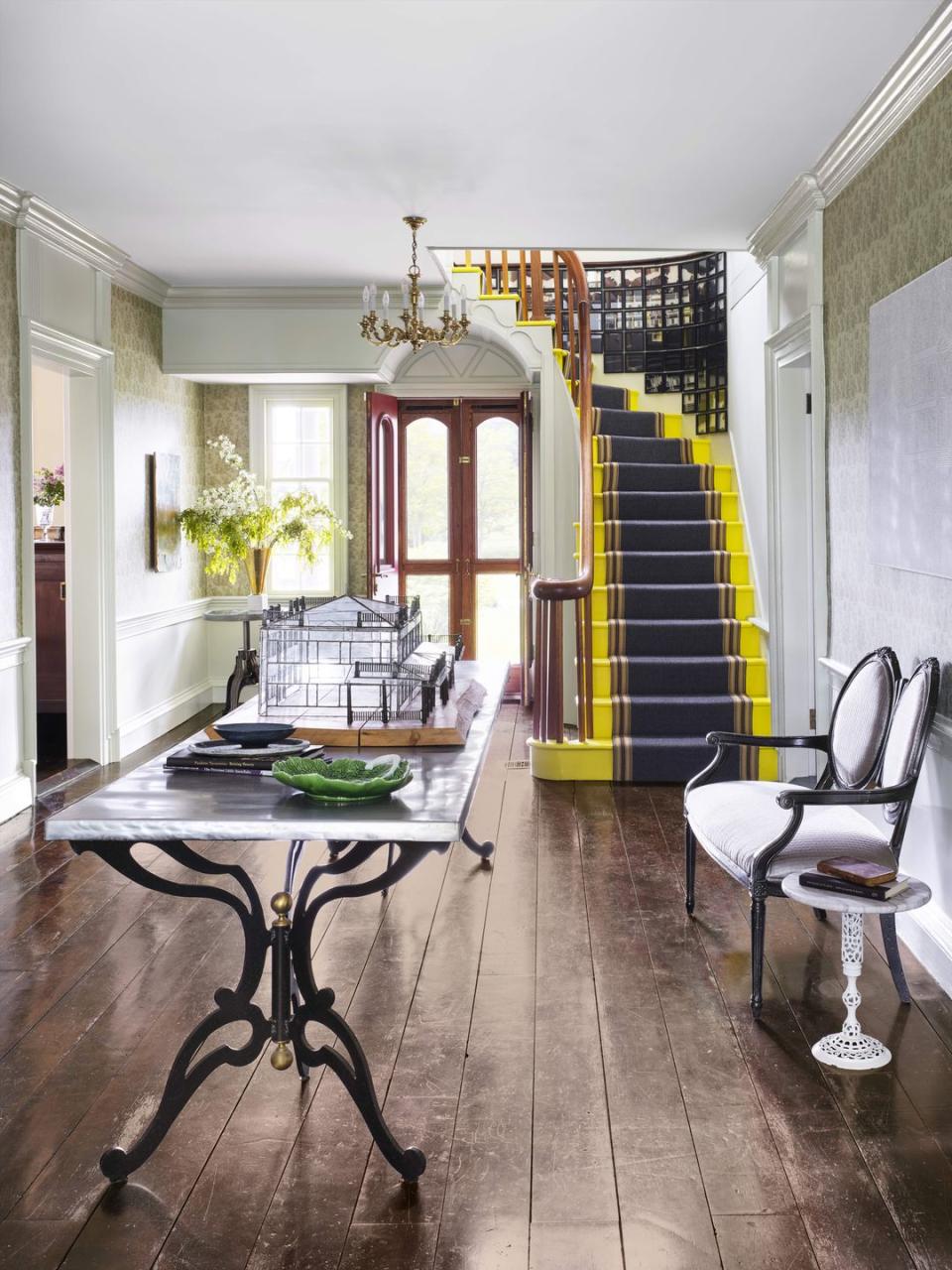 grand entry with bright yellow staircase and traditional furnishings
