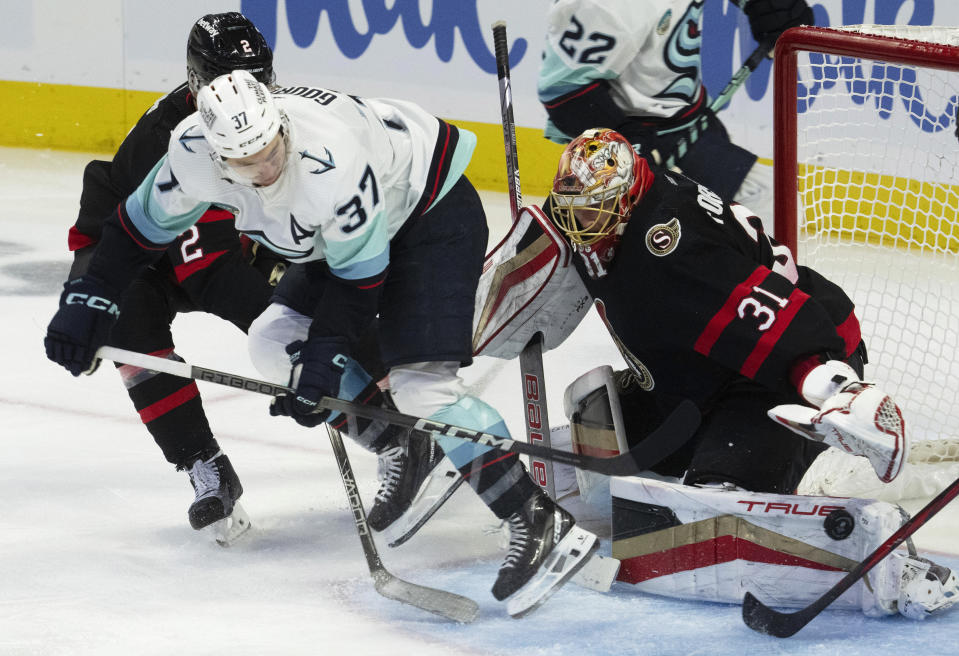 Seattle Kraken center Yanni Gourde (37) tries a backhand shot against Ottawa Senators goaltender Anton Forsberg, right, during third-period NHL hockey game action, Saturday, Dec. 2, 2023, in Ottawa, Ontario. (Adrian Wyld/The Canadian Press via AP)