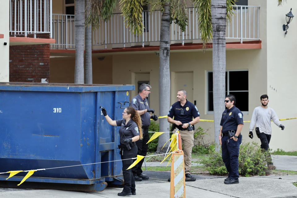 A crime scene investigator dusts for fingerprints at a large trash bin outside of an apartment complex in Hollywood, Fla., where construction workers found a dead baby on Monday, Jan. 8, 2024. (Amy Beth Bennett/South Florida Sun-Sentinel via AP)
