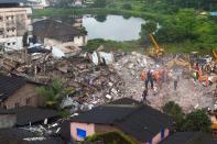 Rescue workers search for people in the rubble of a collapsed five-storey apartment building in Mahad. (Photo by PUNIT PARANJPE/AFP via Getty Images)