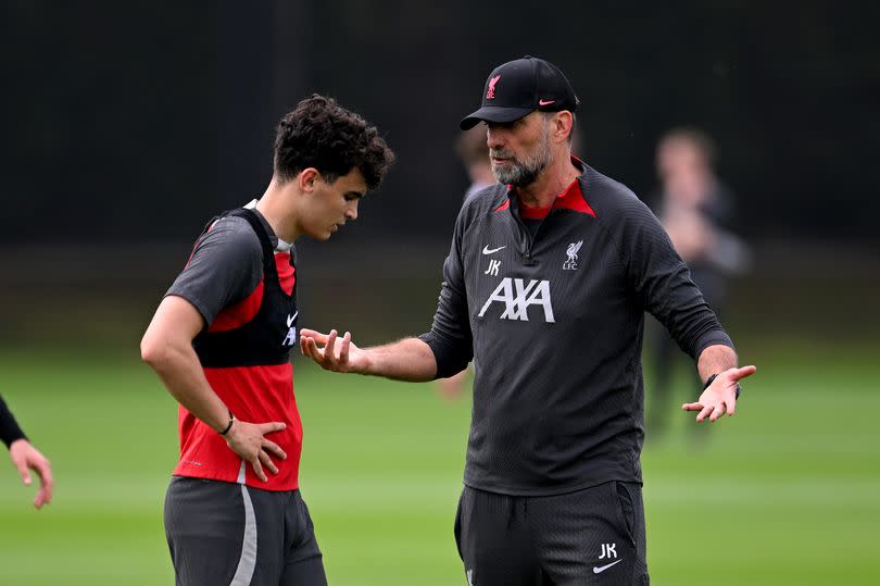 Stefan Bajčetić and Jürgen Klopp engage in a conversation during a Liverpool training session.
