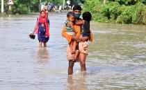 Villagers move to a safer place from the flooded area of Hatisela in Kamrup district of Assam. (Photo credit should read Anuwar Ali Hazarika/Barcroft Media via Getty Images)