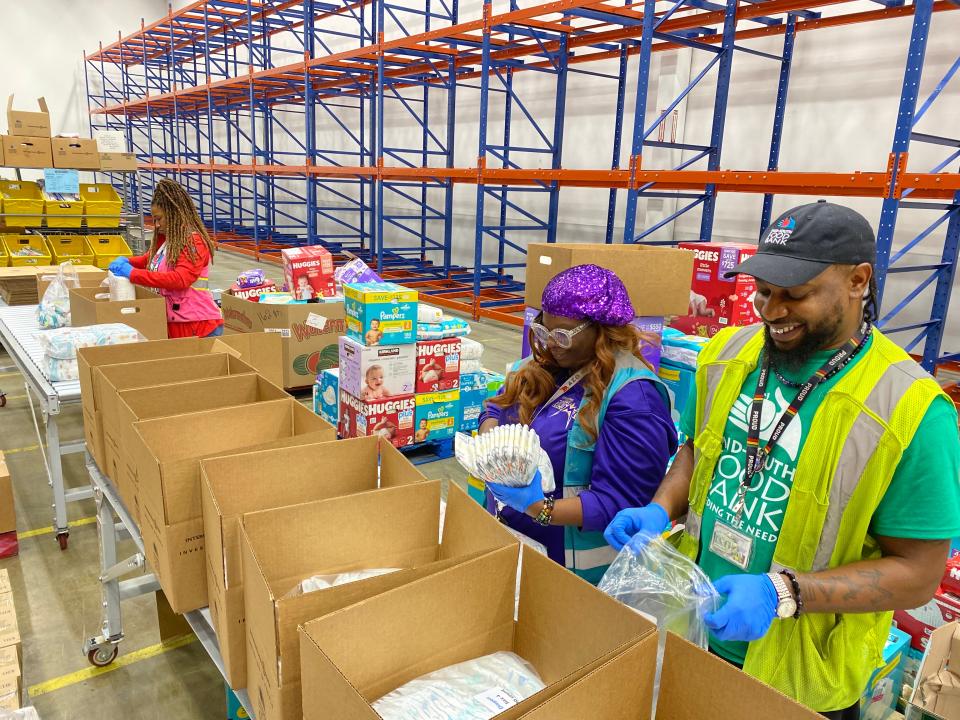 Mid-South Food Bank Director of Agency Partnerships and Program Services Shari Douglas (far left), Diaper Bank manager Dornesha White (middle), and Sir Lawrence Crutcher (right) sort diapers for the Diaper Bank.