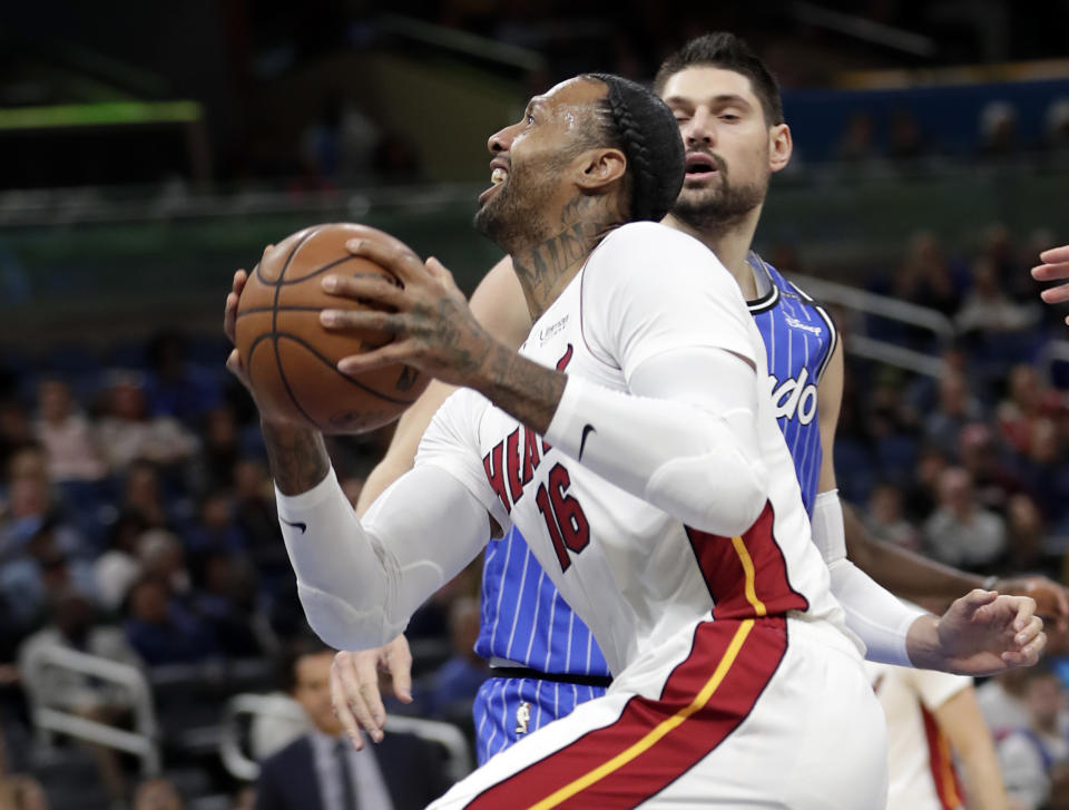 Miami Heat's James Johnson (16) goes to the basket for a shot against Orlando Magic's Nikola Vucevic, back right, during the first half of an NBA basketball game, Sunday, Dec. 23, 2018, in Orlando, Fla. (AP Photo/John Raoux)
