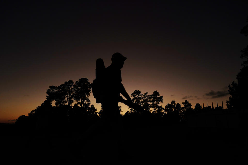 A course Marshall walks off the course after sunset following the first round of the Masters golf tournament Thursday, Nov. 12, 2020, in Augusta, Ga. (AP Photo/Matt Slocum)