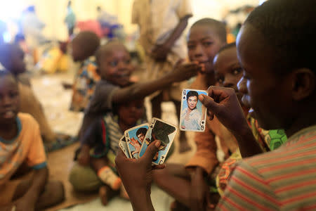 Children who fled ethnic fighting in the Democratic Republic of Congo by fleeing on a boat across Lake Albert, play cards at a United Nations High Commission for Refugees (UNHCR) settlement camp in Kyangwali, Uganda March 19, 2018. REUTERS/James Akena