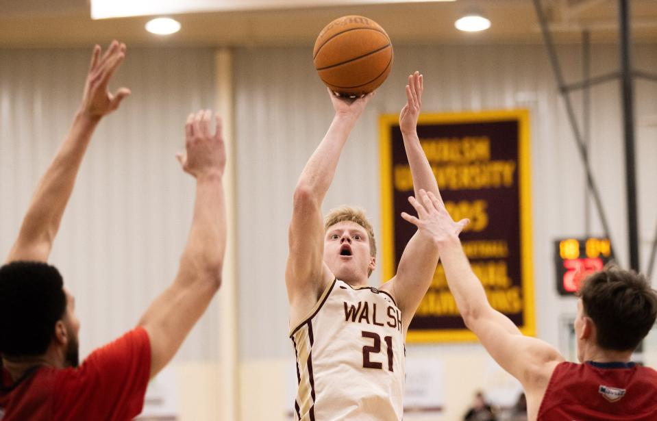 Walsh’s Garrison Keeslar shoots over Malone defenders during a game in February.