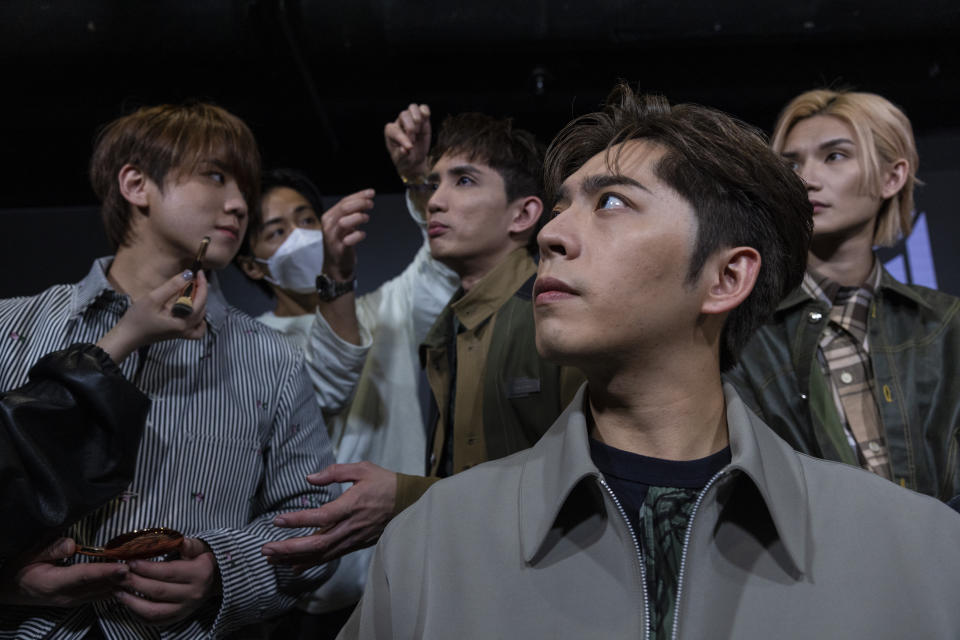 Edan Lui, front, and other members of CantopopbandMirror receive make up during an interview with The Associated Press in Hong Kong on Sunday, March 12, 2023. Hong Kong's most popular boy band Mirror, a major driving force behind the revival of the local pop music scene, launched its first English song on Friday, hoping to bring the city's tunes to music lovers globally. (AP Photo/Louise Delmotte)