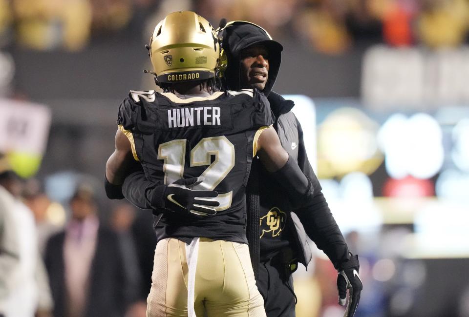 October 13, 2023; Boulder, Colorado, USA; Colorado Buffaloes wide receiver Travis Hunter (12) is congratulated on his touchdown by coach Deion Sanders in the first quarter against the Stanford Cardinal at Folsom Field. Mandatory Credit: Ron Chenoy-USA TODAY Sports