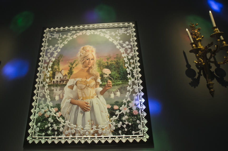 The painted photograph of former escort girl Zahia Dehar is part of the installation by French artists Pierre Commoy and Gilles Blanchard, known as Pierre et Gilles, at the Gobelins Gallery in Paris, Monday, April 7, 2014. Pierre Commoy and Gilles Blanchard, who have established a strong reputation in Europe and beyond for shock ever since their stylized, hand-painted homoerotic photos first appeared nearly 40 years ago. Today, their iconic images of stars such as Madonna, Kylie Minogue, Mick Jagger and Catherine Deneuve which appear alongside naked gay porn stars in glittering and fantastical scenes line coffee-tables the world over and have titillated millions. (AP Photo/Michel Euler)