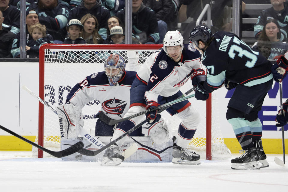 Seattle Kraken center Yanni Gourde (37) shoots on goal with Columbus Blue Jackets goaltender Daniil Tarasov (40) blocking assisted by defenseman Andrew Peeke (2) during the second period of an NHL hockey game, Sunday, Jan. 28, 2024, in Seattle. (AP Photo/John Froschauer)