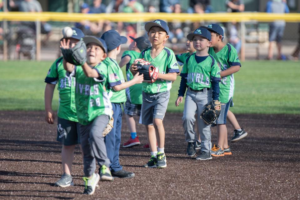 Youngsters catch fly balls thrown by Colorado State University Pueblo baseball players at the 17th annual Art & Lorraine Gonzales youth clinic and Pack the Park event at the Runyon Sports Complex on Friday, April 29, 2022.