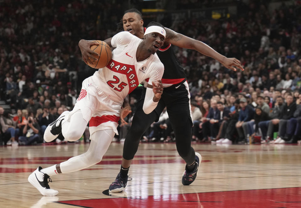 Toronto Raptors forward Chris Boucher (25) drives around Portland Trail Blazers forward Toumani Camara during the first half of an NBA basketball game game in Toronto, Monday, Oct. 30, 2023. (Nathan Denette/The Canadian Press via AP)