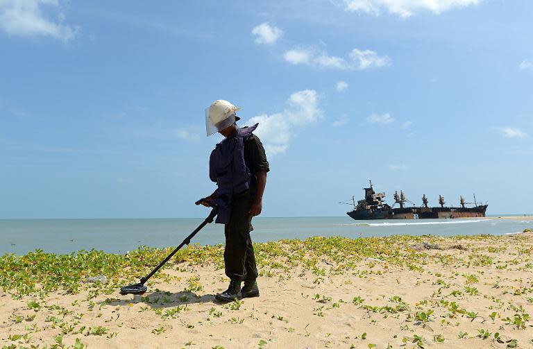 A soldier uses a metal detector in search of landmines and buried weapons, near the north-eastern town of Vellamullivaikkal in the Mullaittivu district, on November 2, 2012