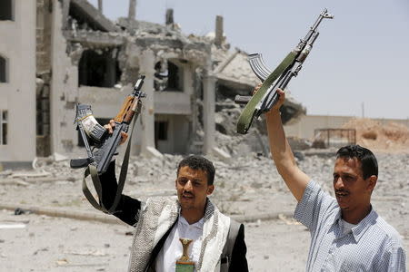 Houthi militants gesture in the yard of the residence of the military commander of the Houthi militant group, Abdullah Yahya al Hakim, after it was hit by an airstrike, in Sanaa April 28, 2015. REUTERS/Khaled Abdullah