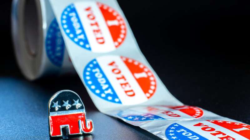 An enamel pin of the Republican Party's elephant symbol next to a roll of "I VOTED TODAY" stickers